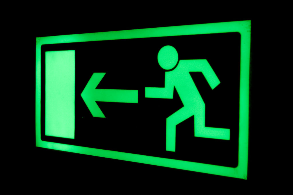 glow in the dark exit sign showing man running to door